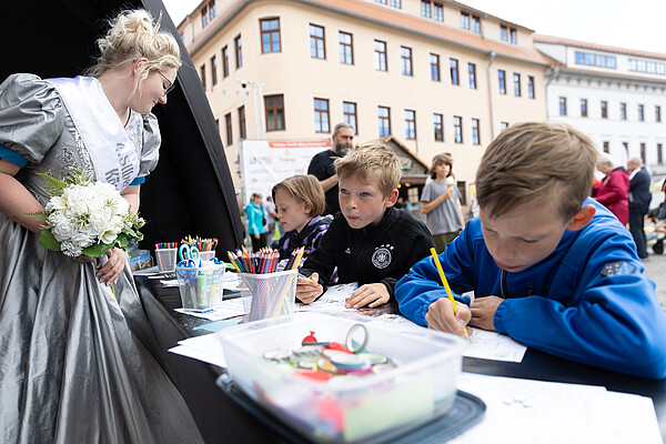 Am Welterbestand am Schloßplatz wurde zum 37. Bergstadtfest eifrig gemalt und gebastelt. Silberstadtkönigin Laura bewunderte die Kunstwerke (Foto: Silberstadt Freiberg, Marcel Schlenkrich)